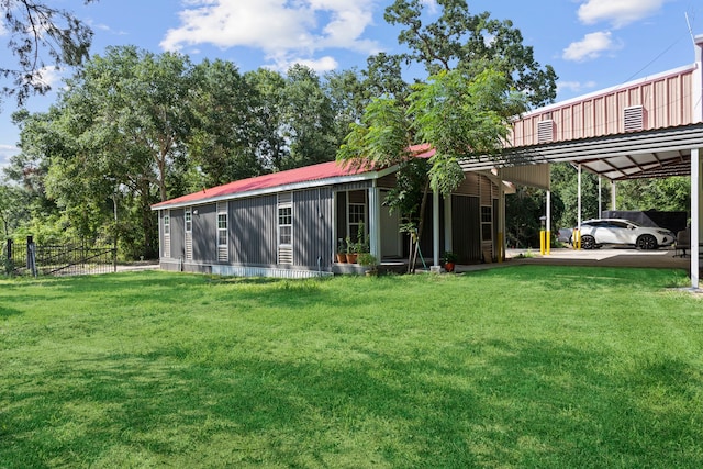 rear view of house featuring metal roof, an attached carport, and a yard