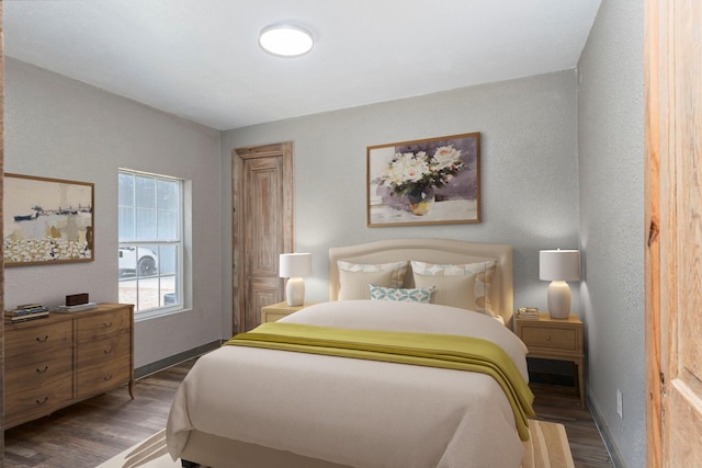 bedroom featuring dark wood-style floors and baseboards