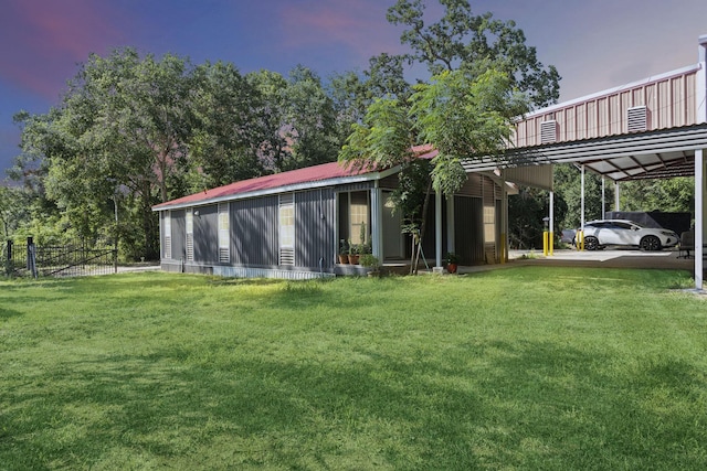 yard at dusk featuring an attached carport