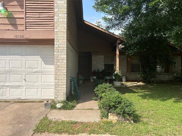 10126 Wild Hollow Ln, Houston, TX 77088 - property entrance with a garage, a lawn, and brick siding
