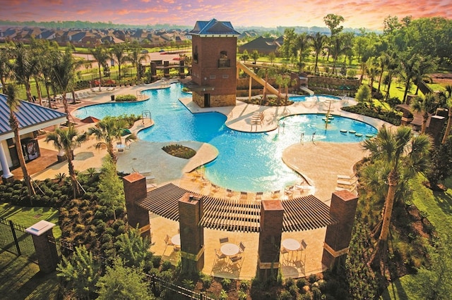 pool at dusk featuring a patio area