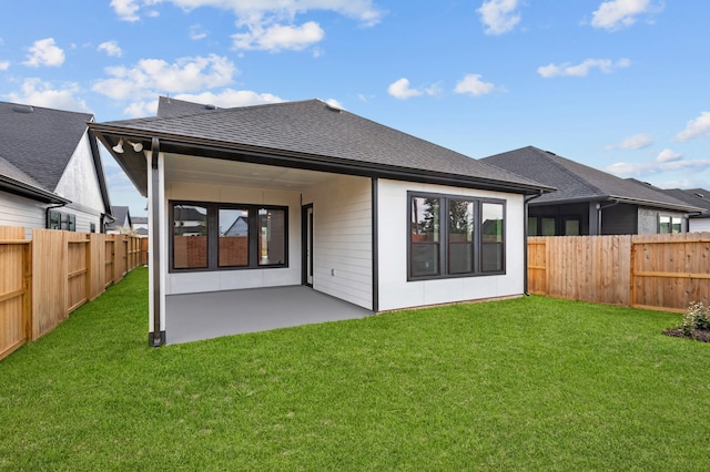 rear view of property featuring a lawn and a patio area