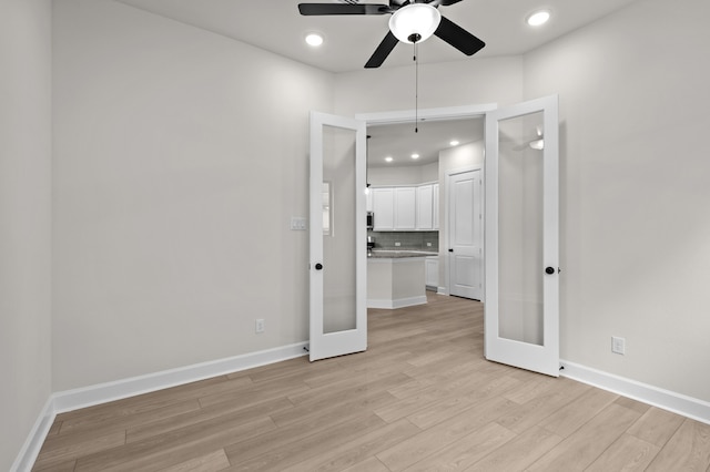 empty room with french doors, light hardwood / wood-style flooring, and ceiling fan