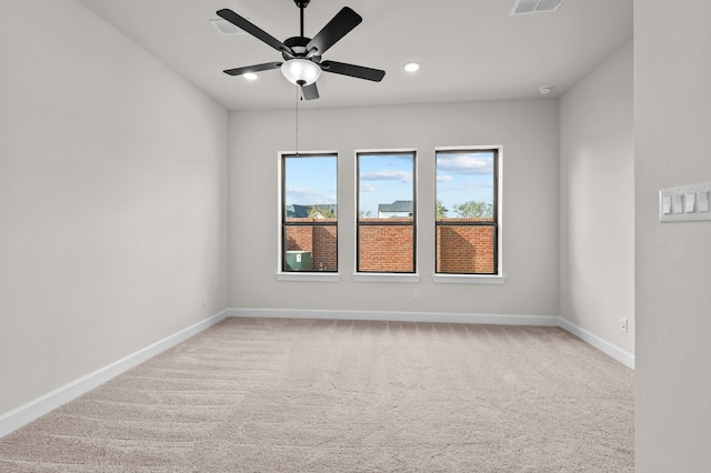 carpeted spare room featuring ceiling fan