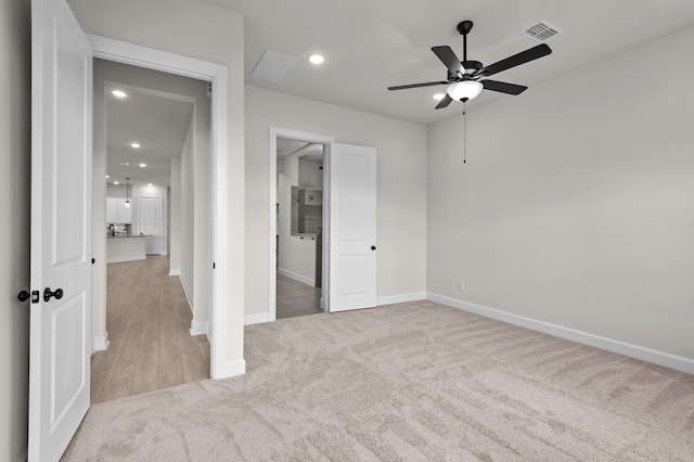 unfurnished bedroom with ceiling fan and light colored carpet