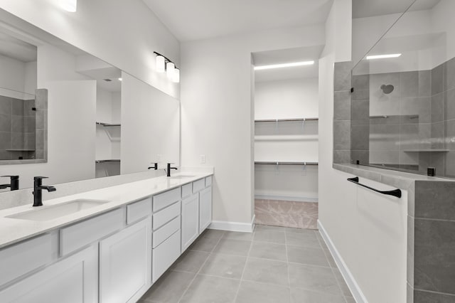 bathroom with tile patterned floors, vanity, and a tile shower