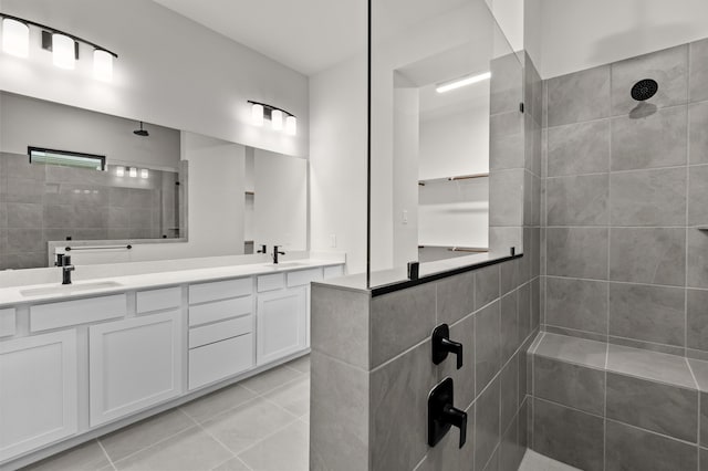 bathroom with a tile shower, tile patterned floors, and vanity