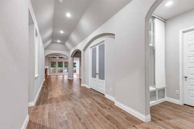 hall with light hardwood / wood-style floors and lofted ceiling