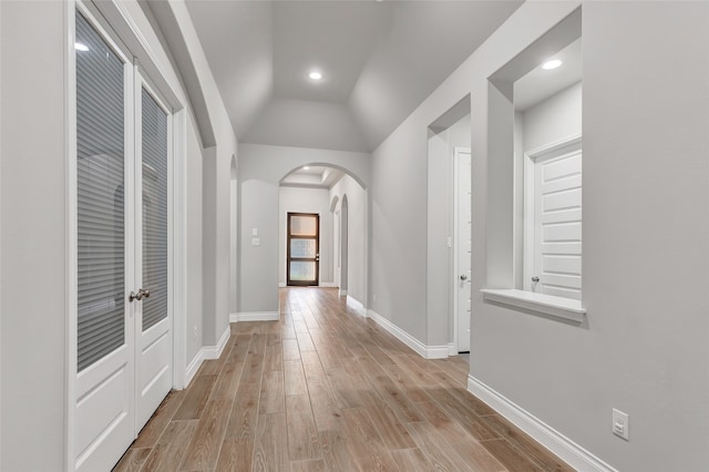 hall with light hardwood / wood-style floors and vaulted ceiling