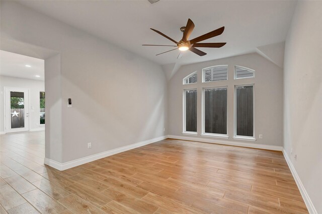 spare room featuring ceiling fan, light wood-type flooring, and vaulted ceiling