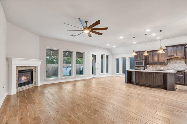 kitchen with pendant lighting, dark brown cabinets, light wood-type flooring, and stainless steel appliances