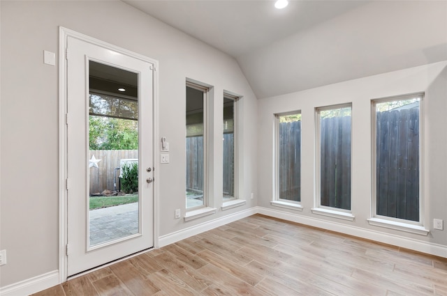 entryway featuring light hardwood / wood-style floors, a wealth of natural light, and lofted ceiling