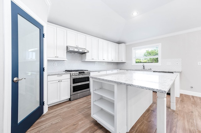 kitchen with light hardwood / wood-style flooring, range with two ovens, white cabinets, and vaulted ceiling