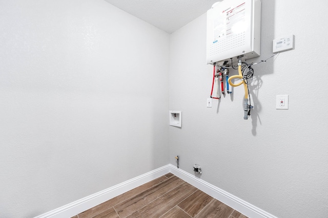 washroom with hookup for a gas dryer, tankless water heater, hardwood / wood-style floors, and washer hookup