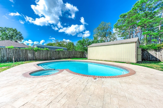 view of swimming pool featuring an in ground hot tub, a patio, and an outdoor structure