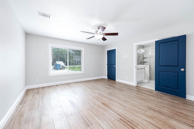 unfurnished bedroom with light tile patterned flooring, ensuite bath, a textured ceiling, and ceiling fan