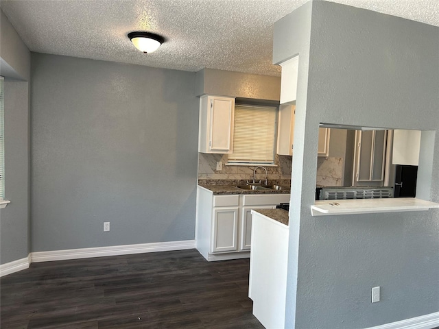 kitchen featuring a textured ceiling, white cabinetry, sink, backsplash, and dark hardwood / wood-style floors