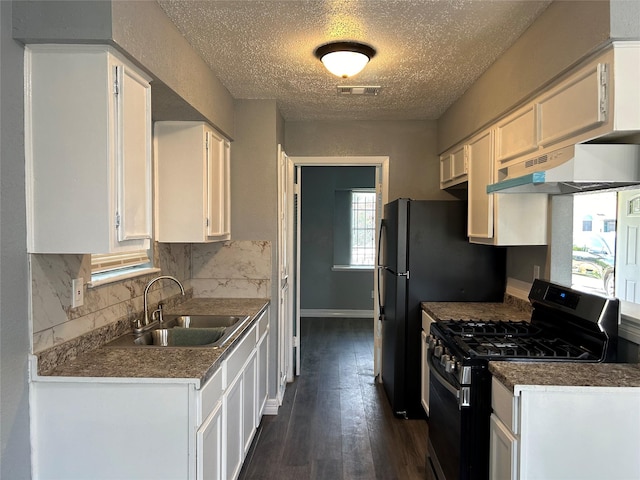 kitchen featuring tasteful backsplash, white cabinets, sink, and gas stove