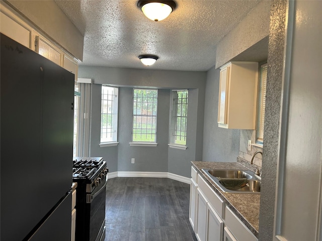 kitchen with white cabinetry, dark hardwood / wood-style flooring, a textured ceiling, black appliances, and sink