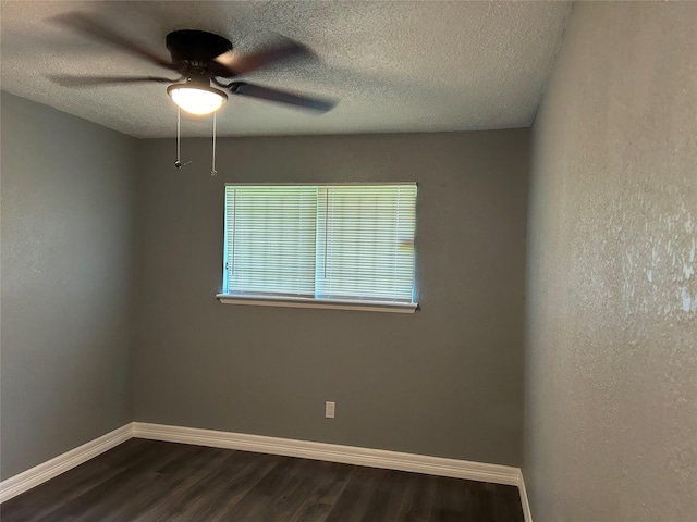 spare room featuring ceiling fan, dark wood-type flooring, and a textured ceiling