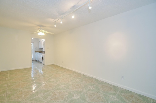 spare room with ceiling fan, a textured ceiling, and washer / clothes dryer