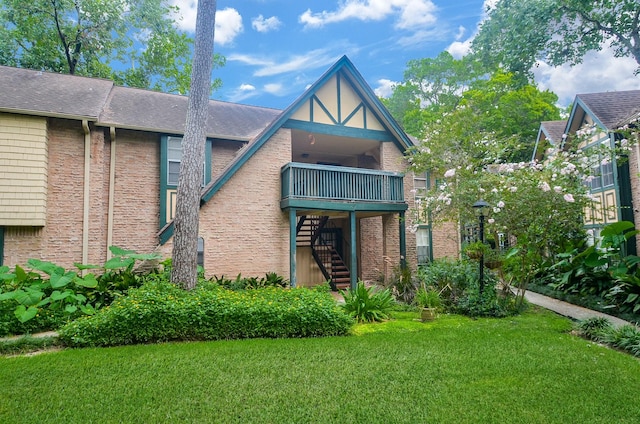 back of house featuring a lawn and a balcony