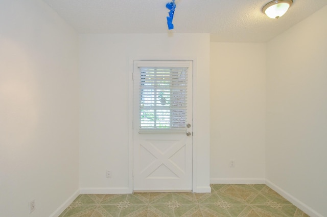 doorway featuring a textured ceiling