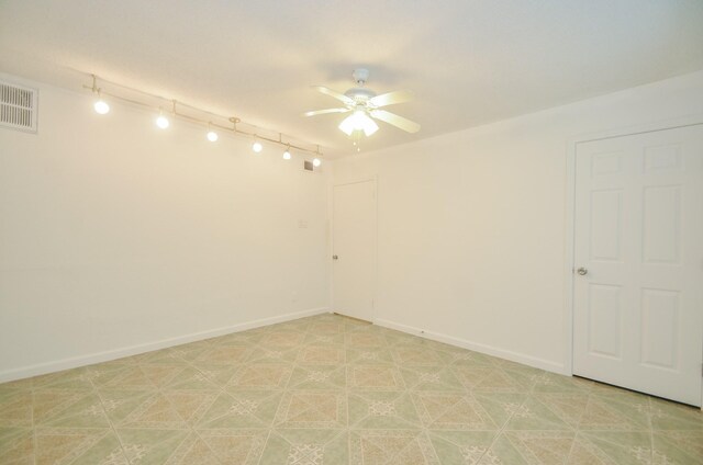 empty room with ceiling fan and rail lighting