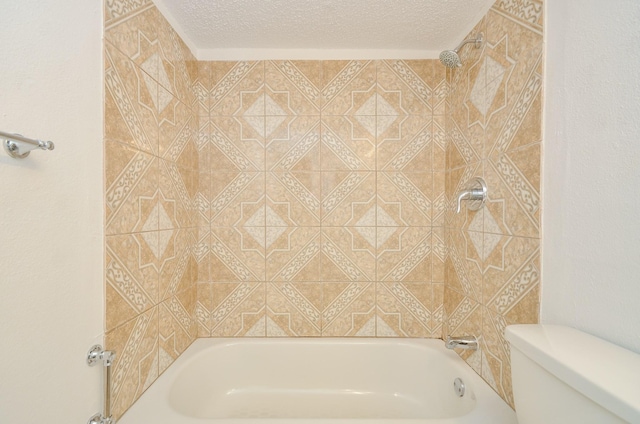 bathroom featuring a textured ceiling, tiled shower / bath combo, and toilet