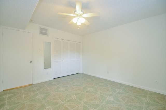 unfurnished bedroom with a textured ceiling, a closet, and ceiling fan