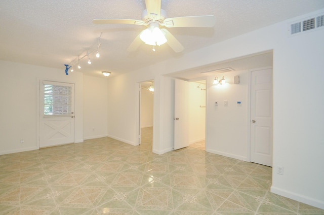 empty room featuring ceiling fan and a textured ceiling