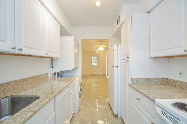 kitchen with light stone counters, white appliances, ceiling fan, white cabinets, and washer / dryer