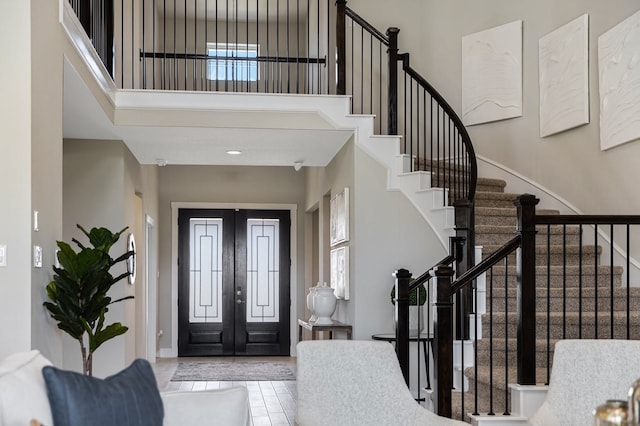 tiled entrance foyer with french doors and a towering ceiling