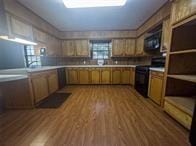 kitchen with a sink, electric range, light countertops, and wood finished floors