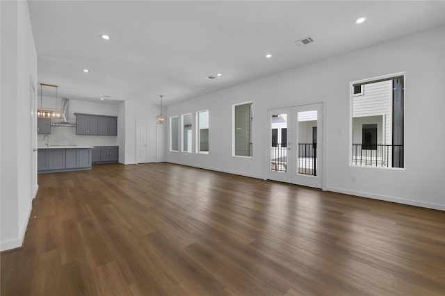 unfurnished living room with dark hardwood / wood-style flooring and french doors