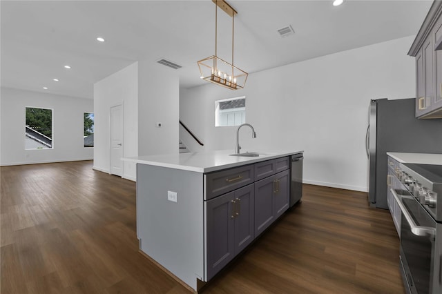 kitchen featuring sink, gray cabinets, an island with sink, and appliances with stainless steel finishes