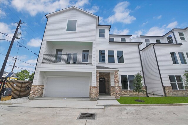 view of front of home with a garage, central AC unit, and a balcony