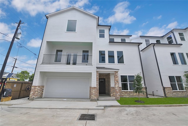 view of front of home with a garage, central AC, and a balcony