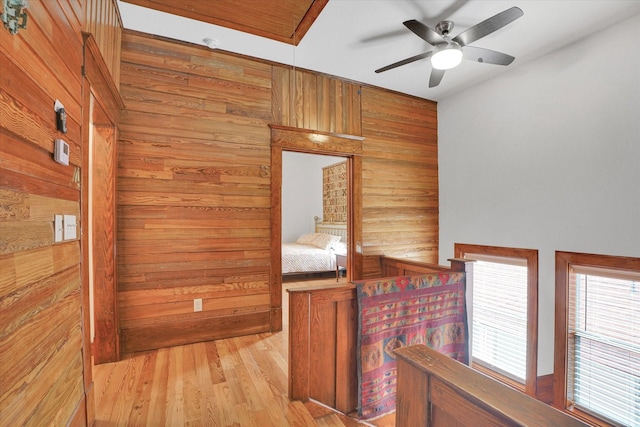 hallway with wood walls and light wood-type flooring