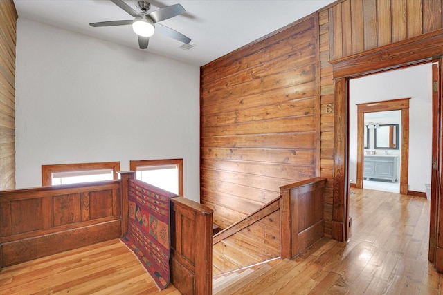 hall featuring wooden walls and light hardwood / wood-style flooring