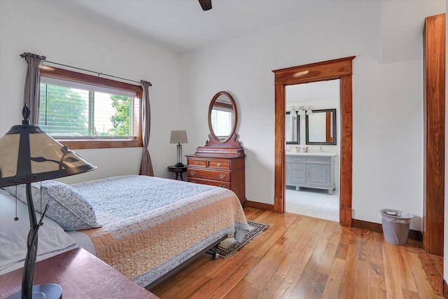 bedroom featuring light hardwood / wood-style flooring, ensuite bath, and ceiling fan