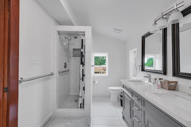 bathroom with plenty of natural light, lofted ceiling, tiled shower, and vanity