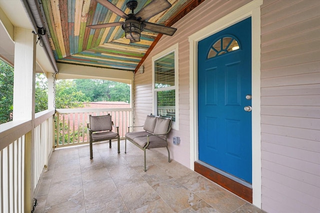 doorway to property featuring covered porch and ceiling fan