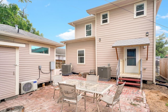 rear view of house with a patio area, ac unit, and central AC unit