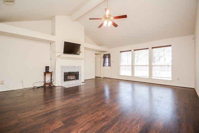 unfurnished living room with visible vents, beam ceiling, a ceiling fan, a tiled fireplace, and wood finished floors