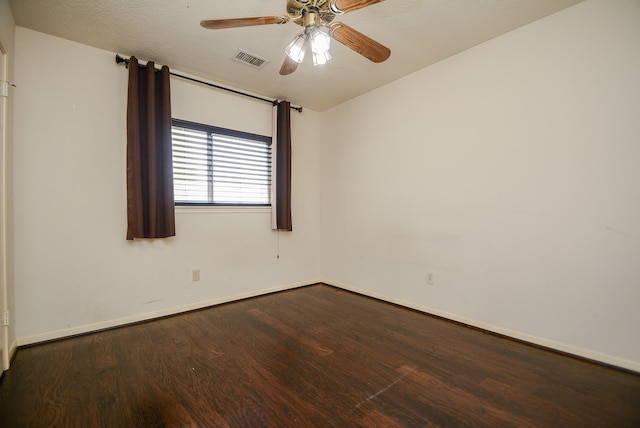 spare room featuring a ceiling fan, wood finished floors, visible vents, and baseboards