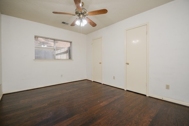 unfurnished bedroom with ceiling fan, wood finished floors, visible vents, and baseboards