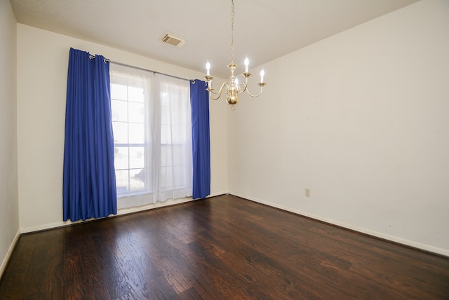 unfurnished room featuring an inviting chandelier and hardwood / wood-style flooring