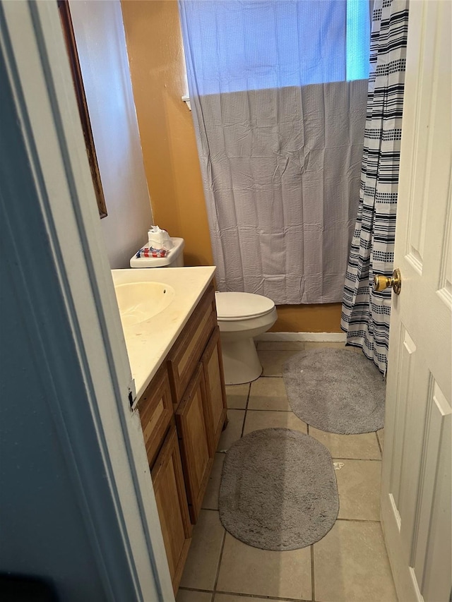 bathroom with tile patterned floors, curtained shower, vanity, and toilet