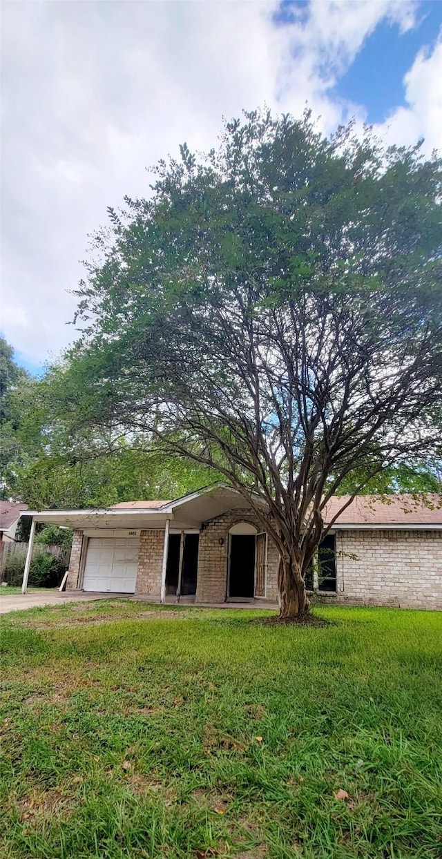 view of front of property with a garage, a front yard, and a carport